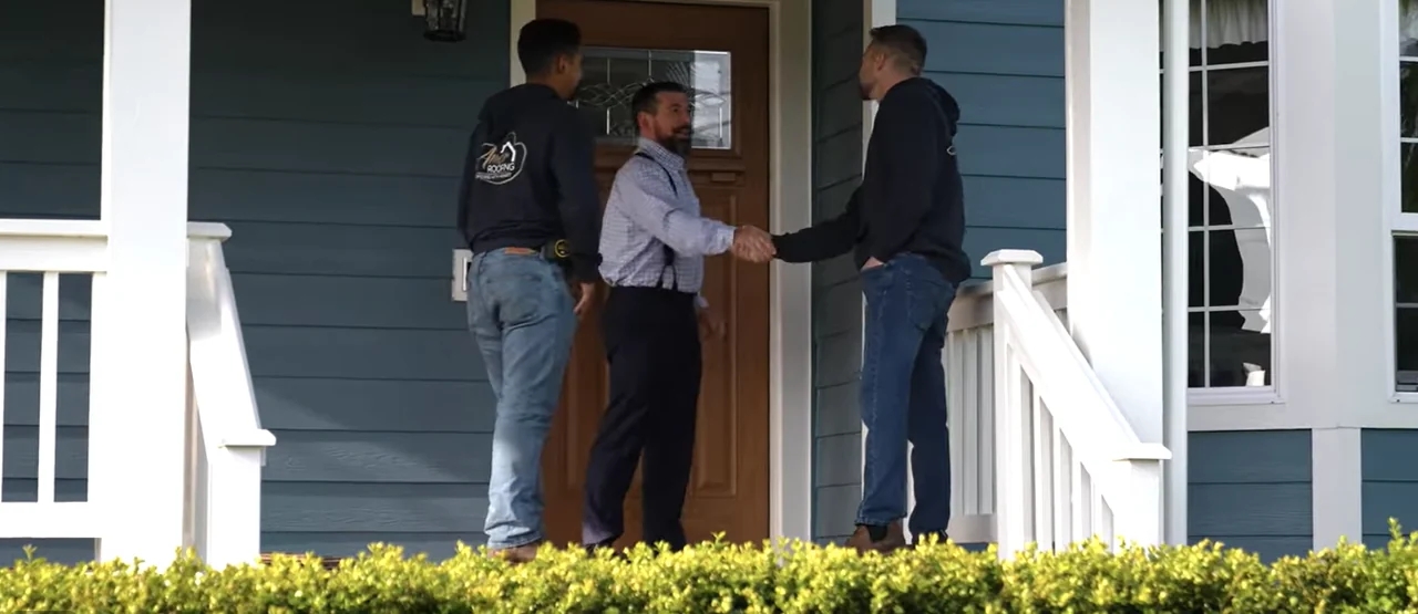 Amor Roofing project consultant meeting a homeowner at the front door before a roof inspection